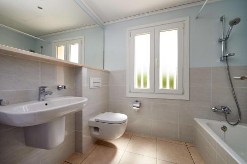 ein Bad mit einem Waschbecken, einem WC und einem Fenster in der Unterkunft Villa Cisne by Oliva Nova in Oliva
