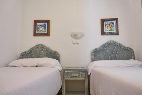 two beds sitting next to each other in a room at Peony by ON Travel in Oliva