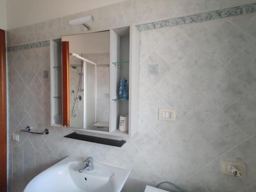 La salle de bains est pourvue d'un lavabo et d'un miroir. dans l'établissement Casa Vacanza Pula, à Pula