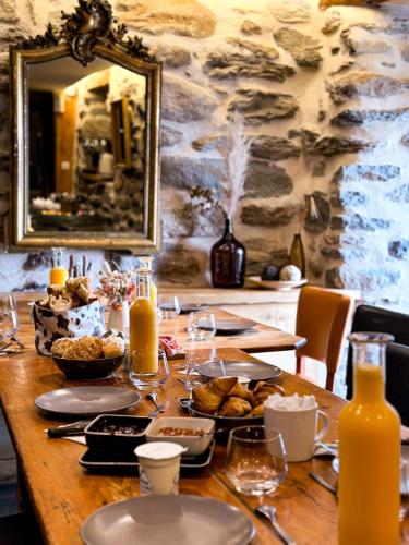 - une table en bois avec de la nourriture et des boissons dans l'établissement La Ferme du Bien-etre, à Saint-Julien-Chapteuil