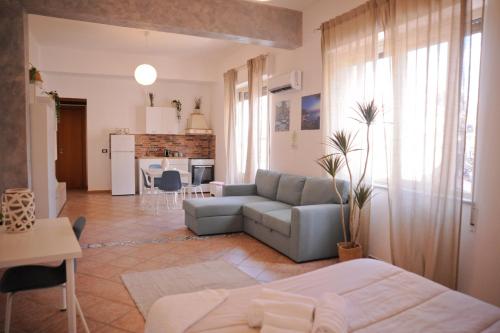 ein Wohnzimmer mit einem Sofa und einer Küche in der Unterkunft Le Finestre su Ballarò in Palermo