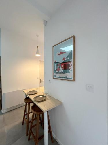 une table dans une pièce avec une photo sur le mur dans l'établissement T1Bis centre ville avec Patio, à Saint-Jean-dʼAngély