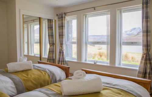 a room with two beds and windows with a view at Taigh Cill Chriosd in Kilbride