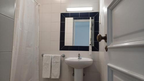 a white bathroom with a sink and a mirror at HI Coimbra - Pousada de Juventude in Coimbra