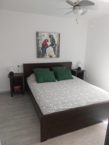 a bedroom with a large bed with green pillows at Apartment Caleta de Fuste in Caleta De Fuste