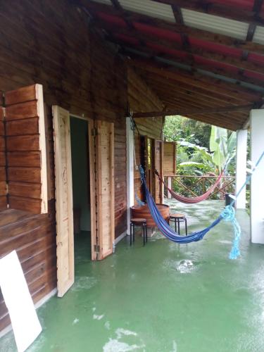 eine Veranda eines Hauses mit einer Hängematte im Wasser in der Unterkunft Berkey's Jungle Paradise Resort in Roseau