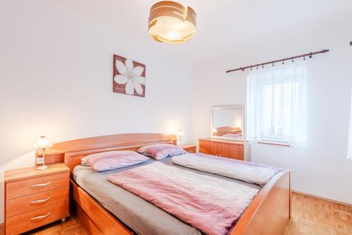 a bedroom with a bed with a dresser and a window at Apartmaji Hosnar in Bovec