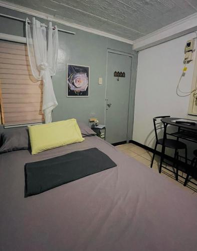 a bedroom with a bed and a table and a window at Nordic Style Homestay Davao in Davao City