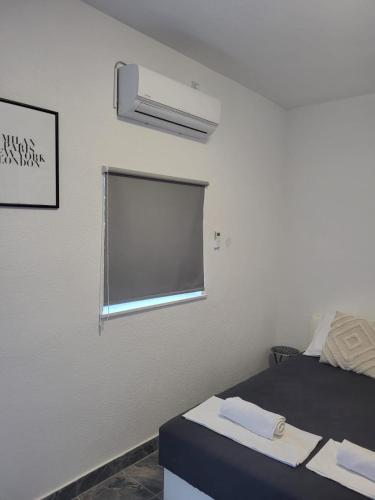 a room with a bed with a window and a fan at Studio Apartman/sobe V&G in Kaštela