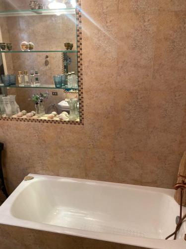 a white bath tub in a bathroom with a mirror at 10 Downtown in Cairo