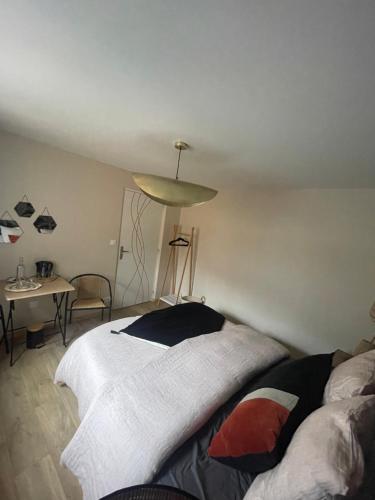 a bedroom with a bed and a table and a lamp at Les chambres du Roc'h Hir à Loguivy de la Mer in Ploubazlanec