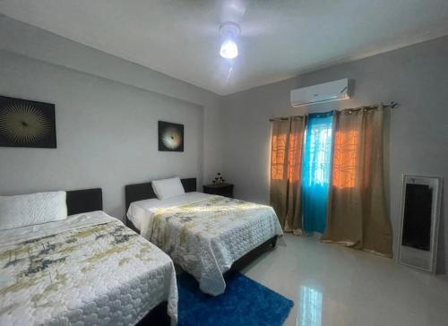 a bedroom with two beds and a television in it at Cozy Elegance 3 Bedroom Estate in Portmore