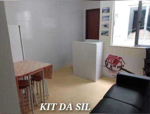 een kleine keuken met een tafel en een koelkast bij KIT DA SIL in Cabo Frio