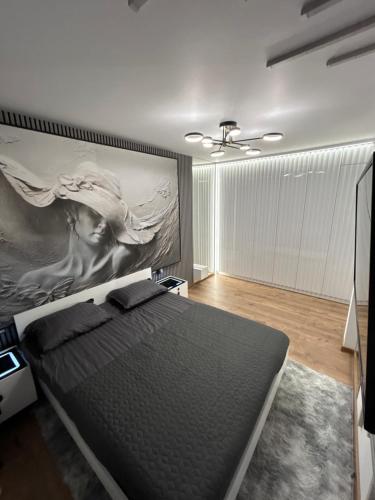 a bedroom with a bed with a painting on the wall at Zeus Ultra Apartament in Baia Mare