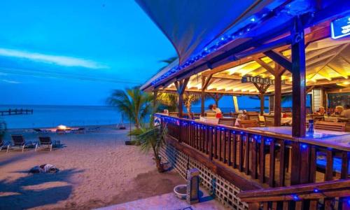 un restaurante en la playa por la noche en Blue Bahia Resort, en Sandy Bay