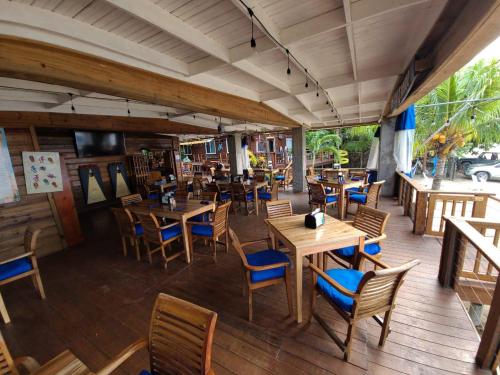 an empty restaurant with wooden tables and chairs at Blue Bahia Resort in Sandy Bay