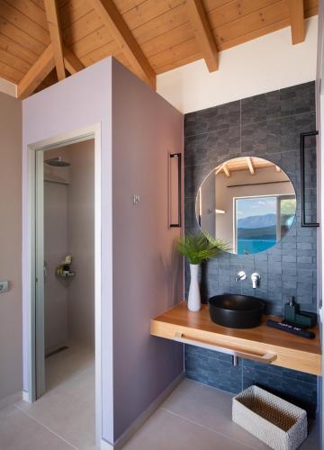 a bathroom with a sink and a mirror at Highview luxury suites in Katouna
