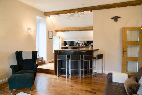 a kitchen and living room with a bar and chairs at The Beeches - Chatsworth Apartment No 5 - Sleep2 in Baslow