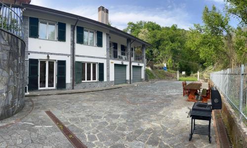 uma casa grande com um pátio de pedra em frente em Casa Perin em Vezzano Ligure