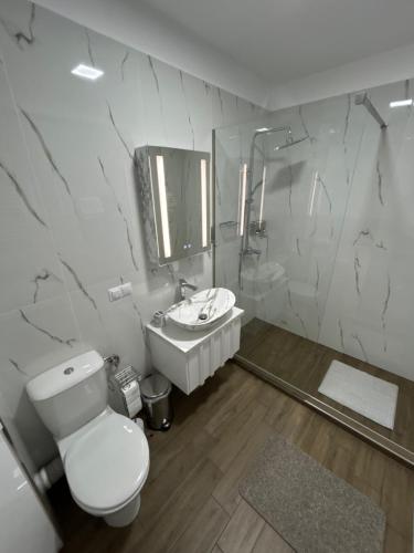 a white bathroom with a toilet and a sink at Zeus Ultra Apartament in Baia Mare
