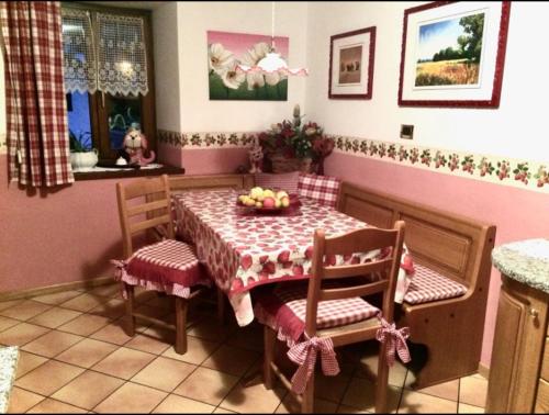 un comedor con mesa y sillas con un bol de fruta en Villa Indipendente en Castello di Fiemme