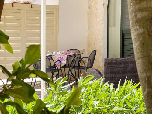 a table and chairs on a balcony with plants at La Maison One B&B in Carovigno