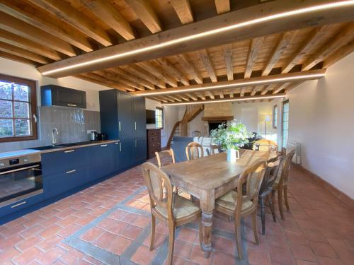 une cuisine et une salle à manger avec une table et des chaises en bois dans l'établissement L'Etape Normande & Jacuzzi, à Sainte-Marguerite-des-Loges