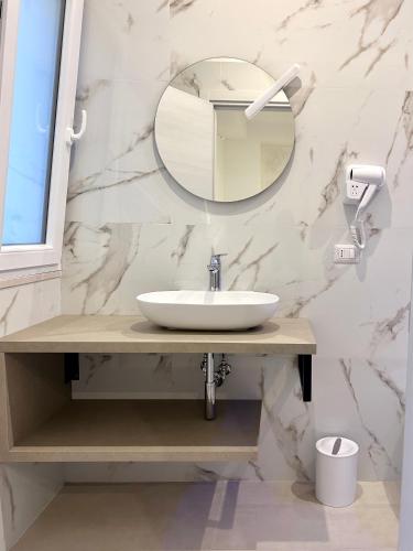 a bathroom with a sink and a mirror at Gemini Luxury Rooms in Peschici