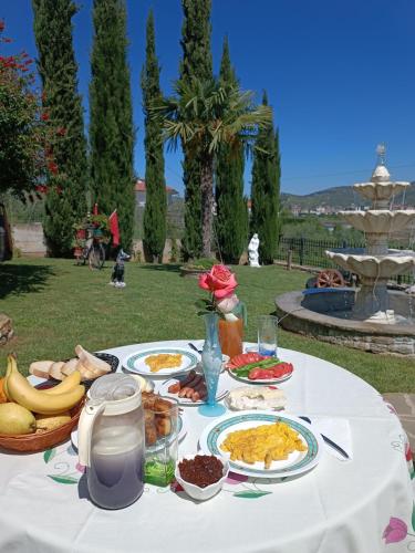 a white table with plates of food on it at Villa Solitude in Berat