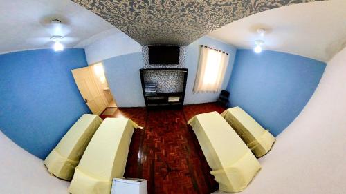 um quarto com paredes azuis e um quarto com cadeiras em CENTRALHE HOTEL em Marília