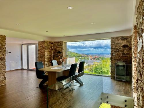 a dining room with a table and a large window at Casa Suomi in Vigo