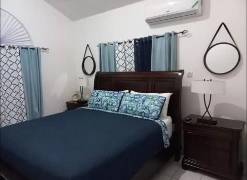 a bedroom with a blue bed with blue pillows at Mi Casa Comfort Estate in Portmore
