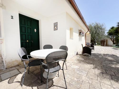 a table and chairs in front of a building at La Maison One B&B in Carovigno