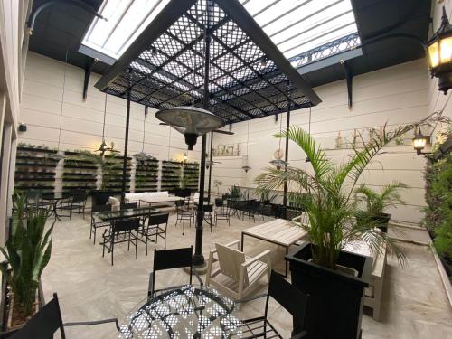 a restaurant with tables and chairs and plants at Amérian Executive Córdoba Hotel in Córdoba