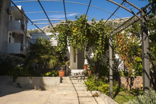 a garden with a pergola and a house at Apartments Sole Mar in Sutomore