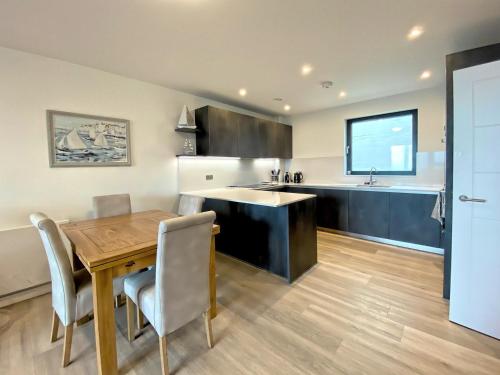 a kitchen with a wooden table and a dining room at SoHot Stays Sail Apt Sea Views Ground Floor Free Parking in Ramsgate