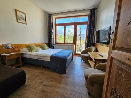 Habitación de hotel con cama y ventana en Pokoje i Apartamenty Krupówki 36, en Zakopane