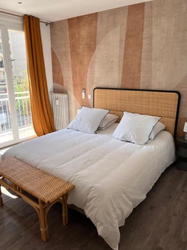 une chambre avec un grand lit blanc et une fenêtre dans l'établissement Appartement avec vue mer, à Nice