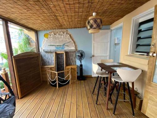 a room with a table and a dining room with a fireplace at La Monarette, l'oasis au fond d'un jardin in Sainte-Marie
