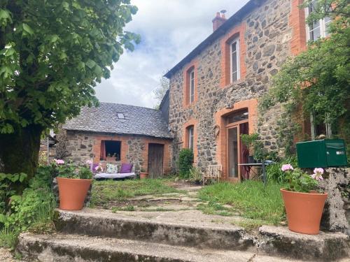 an old stone house with some plants in front of it at Maison d'Hôtes & Savonnerie de Bonnefon in Saint-Chély-dʼAubrac