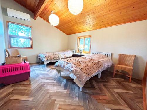 1 dormitorio con 2 camas y techo de madera en villa mori no wankororin - Vacation STAY 69614v, en Tsumagoi