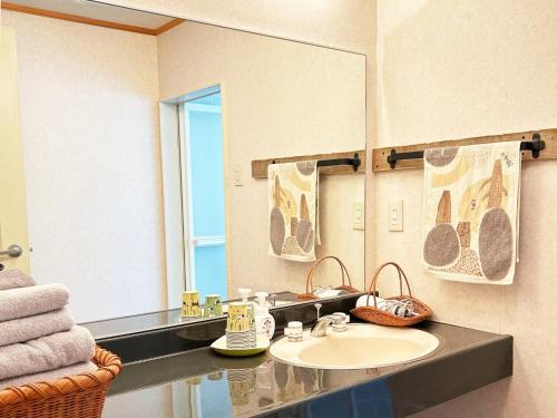 y baño con lavabo y espejo. en villa mori no wankororin - Vacation STAY 69614v, en Tsumagoi