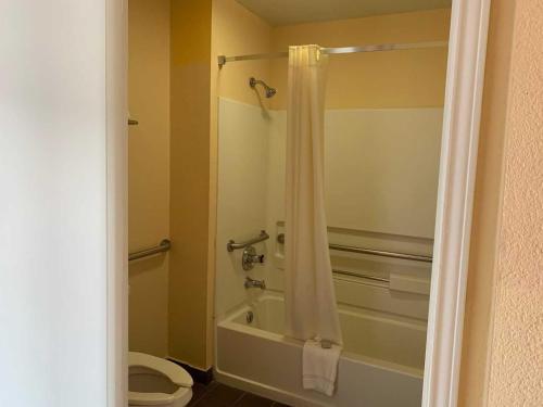 a bathroom with a toilet and a shower with a shower curtain at Key West Inn - Chatsworth in Chatsworth
