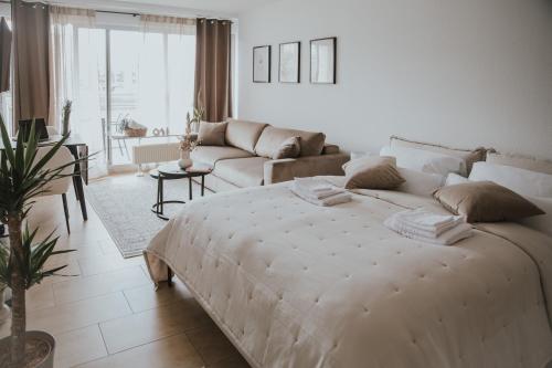 una camera bianca con un grande letto e un divano di Moderne Wohnung mit Weserblick und Uferpromenade a Brema