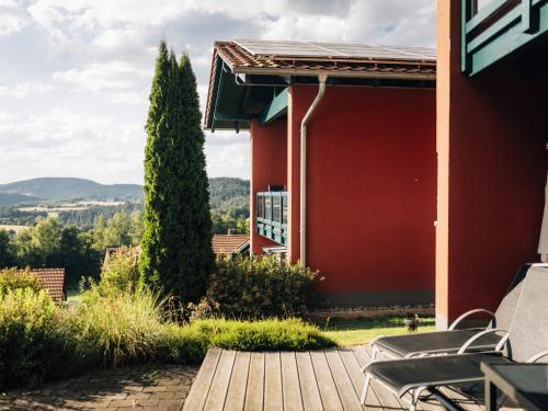 菲希塔赫的住宿－Tranquil Holiday Home in Blossersberg with Terrace，一个带椅子的庭院和一座红色的建筑