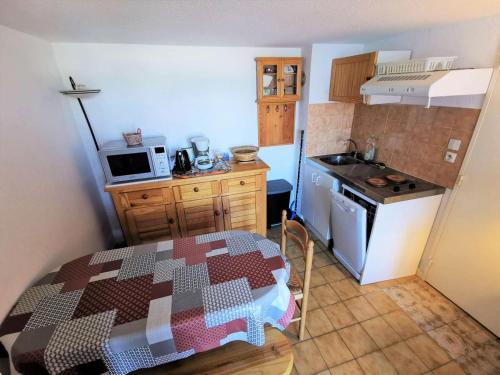 une petite cuisine avec une table, une cuisinière et un évier dans l'établissement Résidence Port Rose 2 - Appartement deux pièces mezzanine - 4 couchages PORT LEUCATE MAE-1681, à Leucate