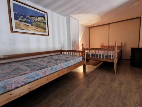 Habitación con 2 camas y una foto en la pared. en Résidence Port Rose 2 - Appartements pour 4 Personnes 681, en Leucate