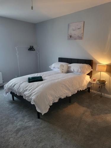 - une chambre avec un grand lit et des draps blancs dans l'établissement Cosy 2 Bedroom House, à Kent