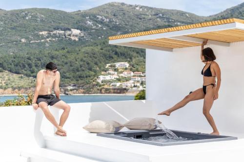 a man and a woman in bathing suits sitting on a balcony at Casa Naturale in Skopelos Town