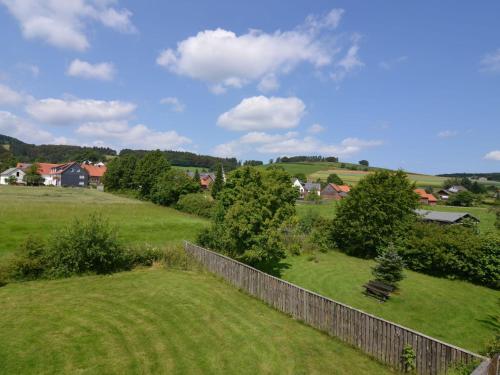 a field with a fence and a bench in the grass at apartment in the Hochsauer region quiet location in Stormbruch